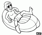 Boy lying down in an inflatable boat with sunglasses