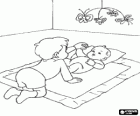 Baby stretched on the floor on his blanket and with a hanging mobile, playing with his older brother