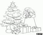 Girl with Christmas gifts near the tree