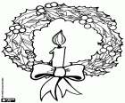 A Christmas wreath made with branches of holly and a candle lit as decoration