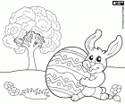 A bunny with an Easter egg on its hand at the garden