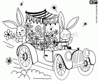 Two Easter bunnies in a vintage car handing out flowers to celebrate Easter